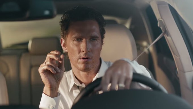 A man in a white dress shirt grips a steering wheel inside a car, wearing a wedding ring and appearing tense or focused while driving. The image conveys the high-risk, high-pressure sentiment of the accompanying post, where the user is ready to gamble $1 million with 50x leverage on $HYPE.