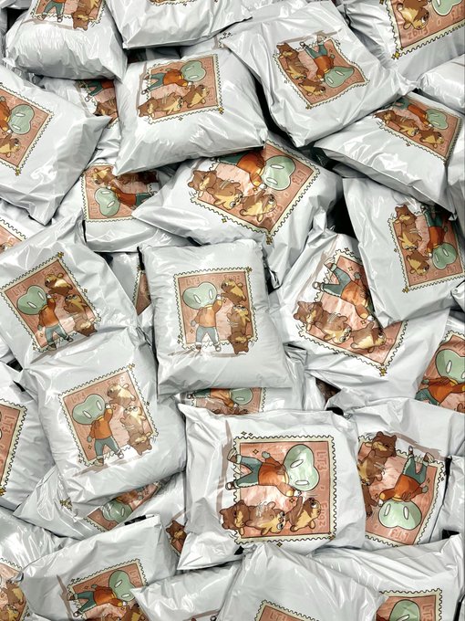 A pile of sealed plastic packages, each containing a card featuring cartoon illustrations of green-headed characters in various poses.