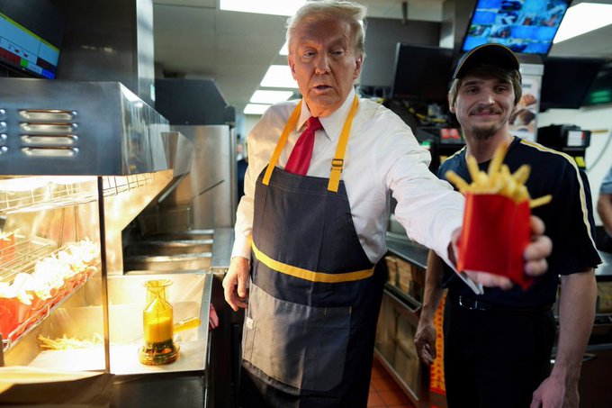 Donald Trump, wearing a branded apron, works behind the counter at McDonald's while handing out a carton of french fries to a customer.

The image serves as a visual metaphor for the post's commentary on fast-food-style trading—grabbing quick "fries" (trades) without carefully choosing a direction, mirroring how Trump briefly staffed a fry station rather than committing to a strategy, just as the post advises waiting out the low-liquidity conditions before fading a move.