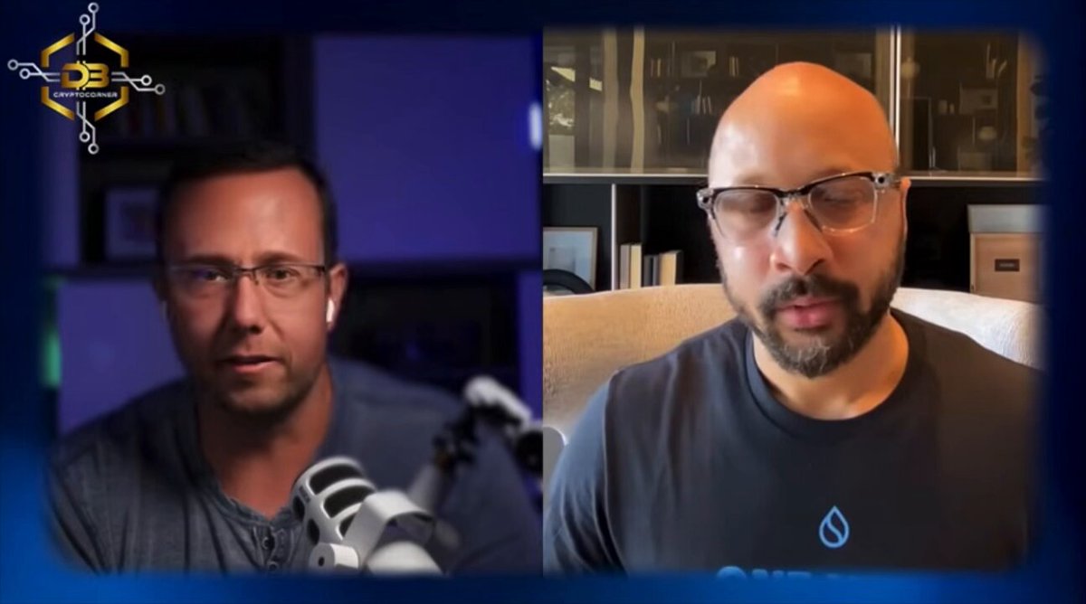 The image shows two men sitting next to each other with their faces turned towards a camera. They appear to be engaged in an interview or discussion about blockchain technology, as indicated by the text "ALERT: SUI STOPPED COMPETING WITH BLOCKCHAINS AND Started competing with the internet adeniYI says the future isn't better chains, it's rebuilding payments, storage, and software on a single programmable layer." The men seem to be discussing the potential impact of blockchain technology on various aspects of daily life.