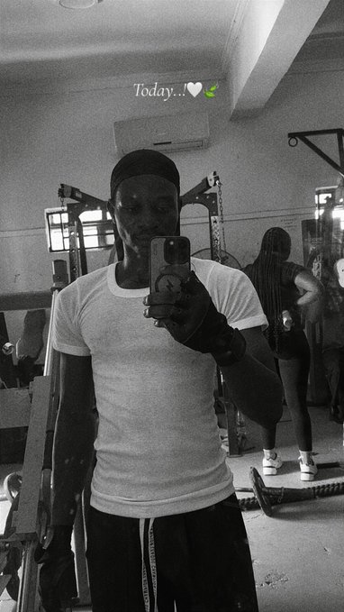 A black and white mirror selfie of a young man in a white t-shirt taking a photo in a gym, with the text 'Today...' and heart emojis at the top.