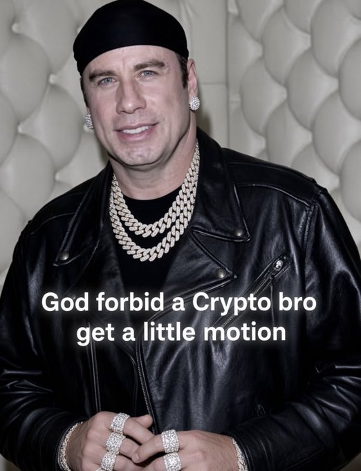 A photo of a man wearing a black beanie, black leather jacket, multiple diamond chains, diamond earrings, and diamond rings, with text overlay reading 'God forbid a Crypto bro get a little motion'.