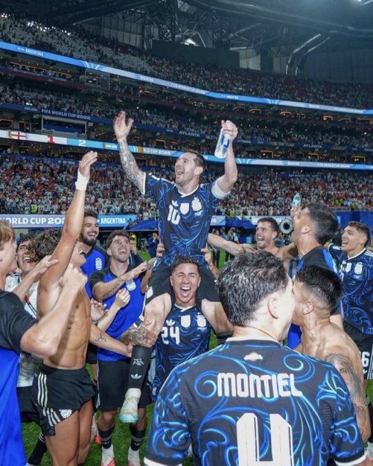 Argentina soccer players celebrate enthusiastically on the field at the FIFA World Cup 2026 stadium in Atlanta, with Messi visible in the center being lifted by teammates amid a cheering crowd.