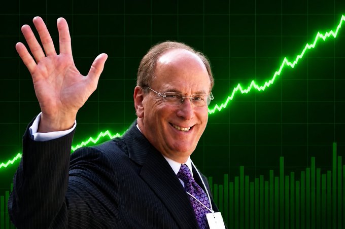 A bald man in a dark suit and purple tie waves and smiles in front of a bright green stock chart showing an upward-trending line and bar graph.