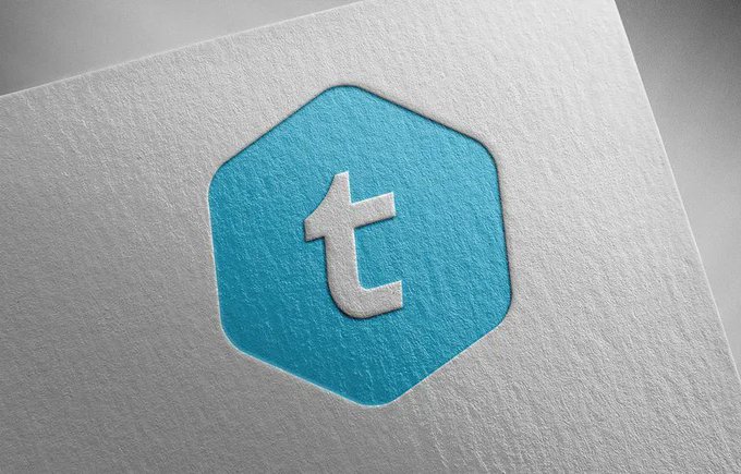 The image features a white piece of paper with a blue logo that reads "T" on it, which appears to be a hexagon shape. The text "TEL WILL LEAD THE USA INTO A NEW FINANCIAL ERA CONNECTION THE TELCOM MARKET (7B+ CUSTOMERS) TO CRYPTO & BANKING." is also present in the image. This logo and accompanying text suggest that the paper may be related to a business or organization involved in telecommunications, finance, or technology. The combination of blue and white colors adds visual interest to the design, making it stand out against the white background of the paper.