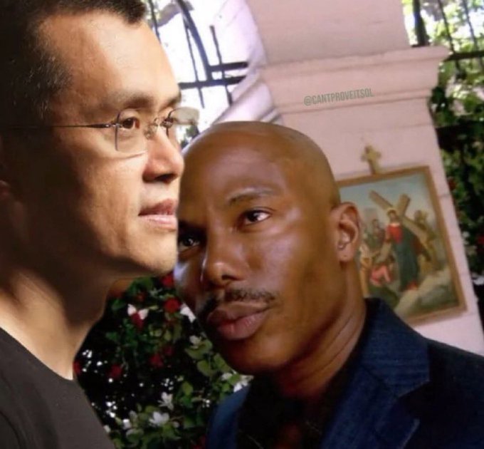 Two men pose for a close-up photo in front of a framed crucifixion scene, with one man bearing a striking resemblance to Binance CEO Changpeng Zhao ("CZ") sporting his signature close-cropped haircut and glasses. A watermark reads "@CANTPROVEITSOL" in the upper right. The caption "I know a CZ candle when I see one" plays on the resemblance, humorously suggesting the bald second man's smooth, rounded head resembles a candlestick used in crypto trading charts.