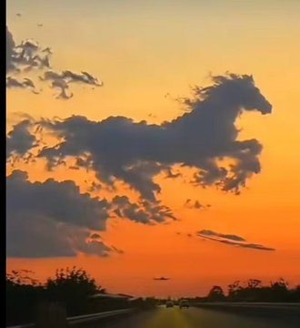 A sunset sky with clouds shaped like a galloping horse.