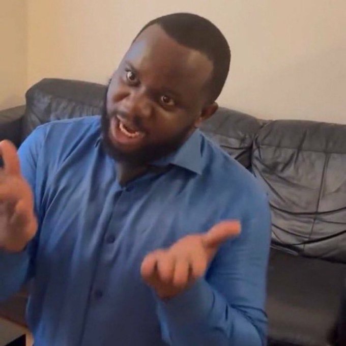 A bearded man in a blue button-up shirt sits on a black leather couch, gesturing animatedly with both hands while speaking enthusiastically. The image appears to be a still from a video pitch or ad promoting a "fly" or matchmaking/connection service, with his expressive demeanor conveying excitement about helping people find meaningful connections.
