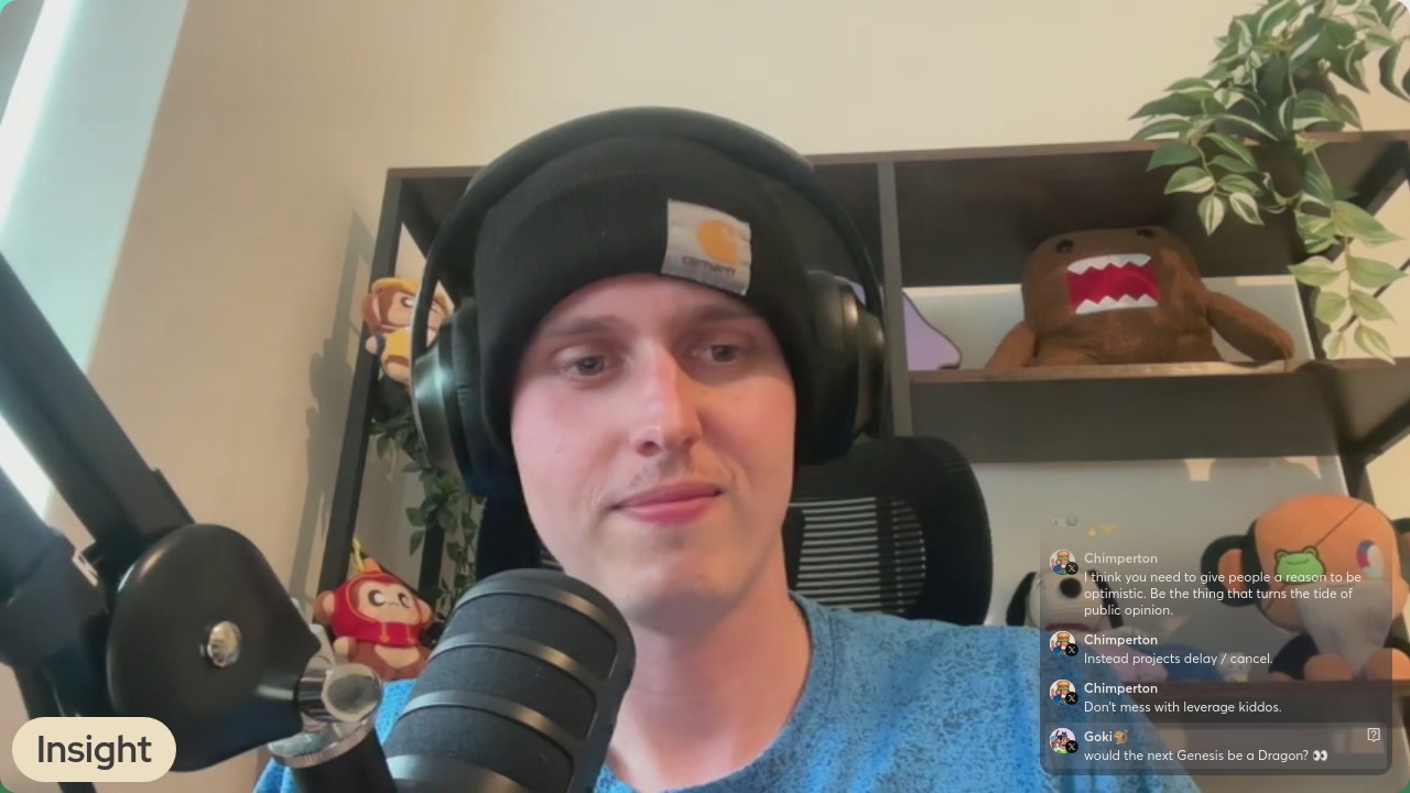 The image shows a man wearing headphones, sitting behind a microphone, and talking into it during an online chat session with other people. There are multiple people visible in the background of the image, suggesting that they might be participating in a group discussion or event. The caption for this image reads "Focus on what is in the image and how it relates to the post: 'Join us chatting all things Chimpers Evolutions!'"