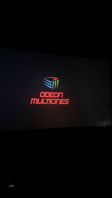 A glowing red and blue logo for 'ODEON MULTICINES' displayed on a dark screen, likely a cinema pre-show.