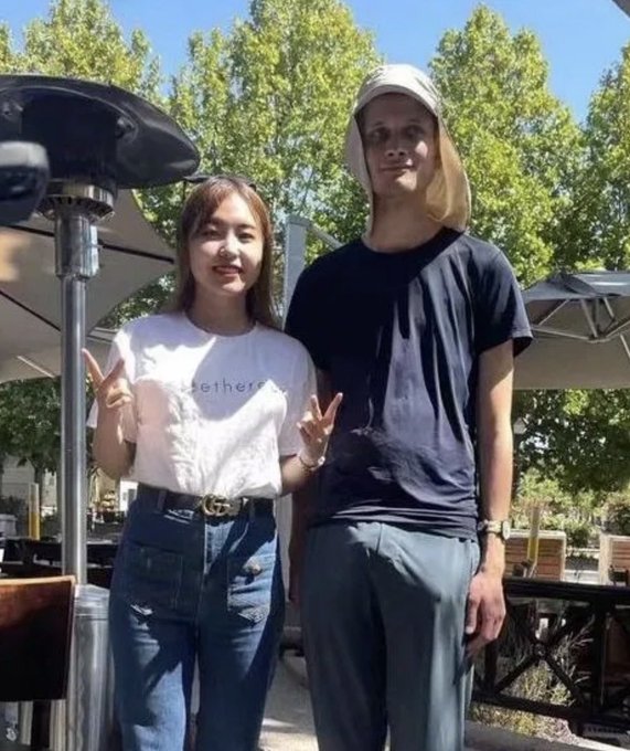 A young woman wearing a white "Together" t-shirt poses with a peace sign next to a taller man in a black t-shirt and white cap at an outdoor patio. The post appears to be a Vietnamese crypto commentary about Ethereum (ETH), referencing Vitalik Buterin, suggesting over 20% of accounts rely on him and warning that if ETH doesn't pump this cycle, there will be consequences—a humorous "Make ETH great again" jab likely tied to Buterin's influence on the project's direction.