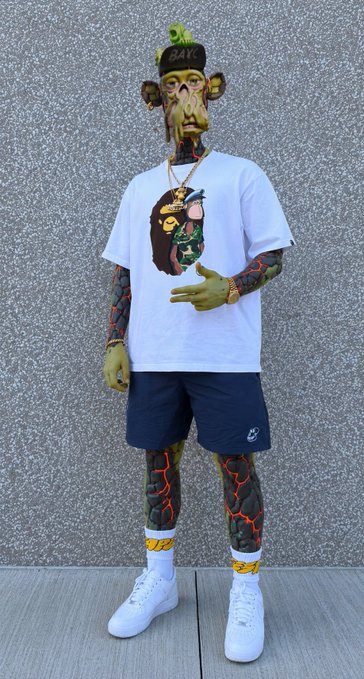 The image shows a stylized 3D-character avatar with green skin, tattoos, and a BAYC cap, wearing a white graphic tee, navy shorts, and high-top sneakers while posing against a gray speckled wall. The caption likely ties into the post's promotion of Web3/NFT gaming events, with the cartoonish "ape-like" figure representing the NFT crypto culture behind Chaos Trials and the day's scheduled Twitter Spaces.