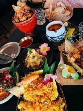 An overhead shot of an elaborate meal featuring various plated dishes—including fried items, dumplings, garnishes with edible flowers, and a bowl of soup—spread across a dark table. The post cleverly suggests using the cost of dining out (around 200 RMB) to bypass WeChat transaction fees via crypto payments, tying the lavish spread to a "Crypto Survival Plan."