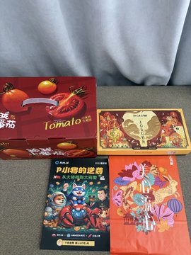 Several gift boxes are arranged on a surface, including a red "Tomato" themed box, a "Crazy Rich Asians" game, and a "Brawl Stars" themed card or book.