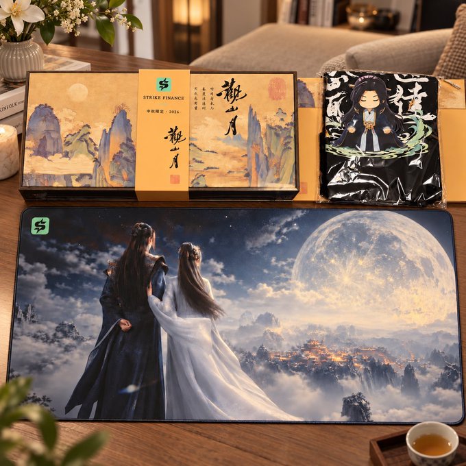 The image shows a Strike Finance Mid-Autumn Festival gift set featuring a traditional Chinese landscape-themed box, an anime character T-shirt, and a large mouse pad depicting two figures in ancient Chinese attire gazing at a luminous moon over mountains, with "STRIKE FINANCE" and "2024" branding visible on the packaging.