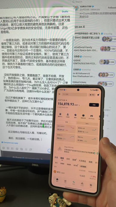 A smartphone displaying an OKX cryptocurrency app showing a USDT balance of 156,878.93, held in front of a computer screen displaying Chinese text and cryptocurrency news on social media.