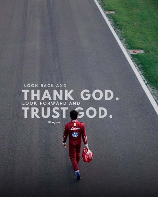 A racing driver in a red Ferrari racing suit walks down an empty asphalt track carrying a red bag, with overlaid text reading 'LOOK BACK AND THANK GOD. LOOK FORWARD AND TRUST GOD.' credited to liv_2621.