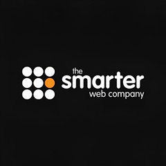 A logo for 'the smarter web company' on a black background, featuring a grid of white and one orange circle.