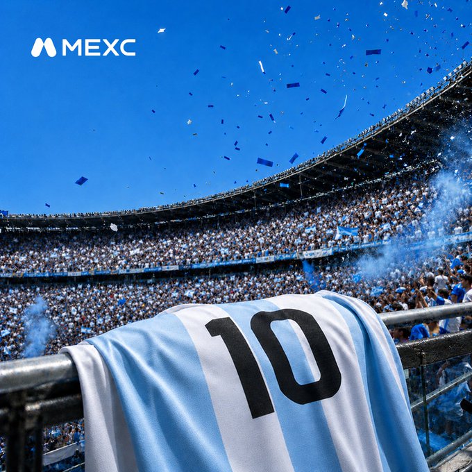 A packed stadium filled with cheering fans waving blue and white confetti, with an Argentina national team #10 jersey draped over a railing in the foreground and the "MEXC" logo displayed in the upper left. The scene captures the electric atmosphere surrounding Argentina's (La Albiceleste) back-to-back finals appearance, honoring Messi's MOTM performance and their quest to lift the trophy again.