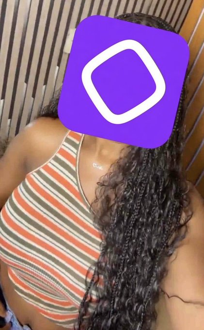 A woman with long curly hair wearing a striped top takes a selfie, her face obscured by the purple Monad crypto logo. The image playfully matches the post's flirty tone, visually representing the "her" (Monad) being admired, with the iconic purple branding serving as a stand-in for the coin's presence in the author's daily life.