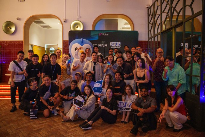 A large group of people pose together at an indoor venue in front of a backdrop featuring the logos 'Solar', 'CUBANA', and 'TRIO network'.