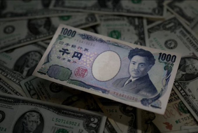 A Japanese 1000 yen banknote featuring Hideyo Noguchi is displayed on top of a scattered pile of United States one and two dollar bills.
