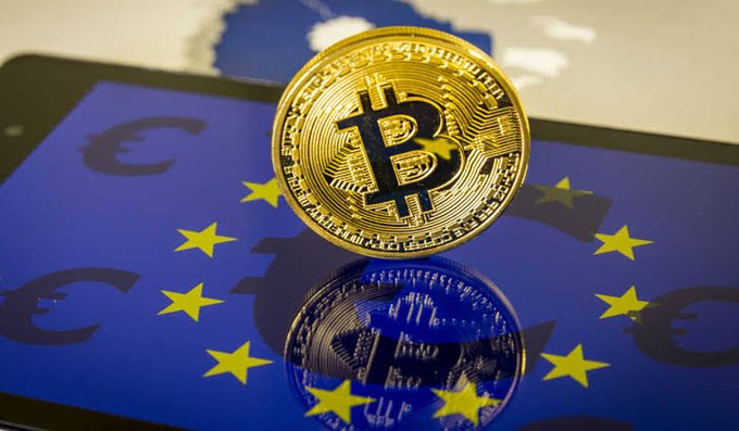 A physical Bitcoin token rests on a smartphone screen displaying the European Union flag with stars and a map of Europe, symbolizing the intersection of cryptocurrency and EU regulation.

The image visually ties into the post by representing how the EU's proposed MiCA expansion would bring digital assets like Bitcoin and stablecoins under a unified regulatory framework across European markets.