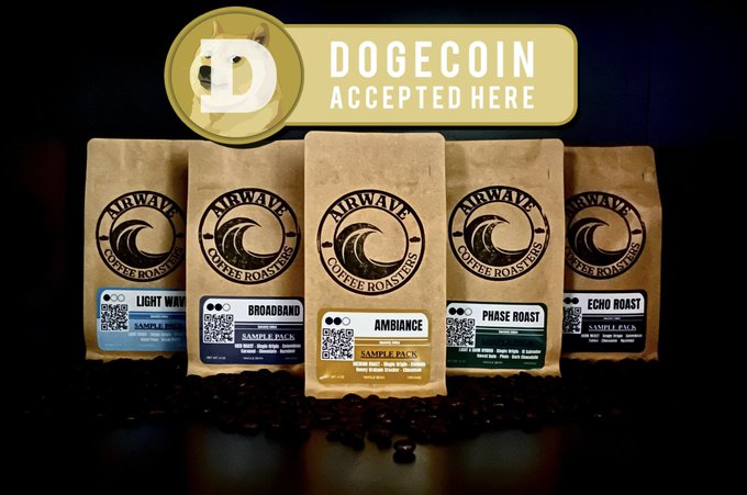 The image features five bags of coffee beans, each with a different flavor or roast level printed on them. The bags are arranged in two rows against a black background, creating an appealing visual contrast. The text "DOGEcoin accepted here" is displayed above and below the bags, indicating that these coffee bags can be used to purchase Dogecoin.