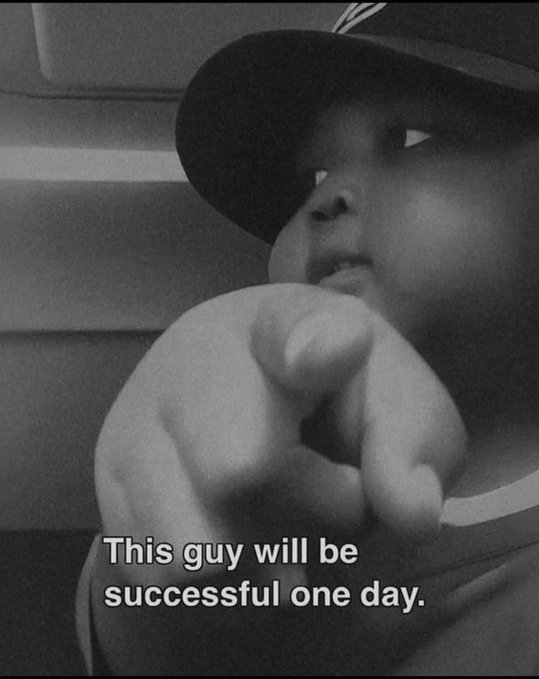 A black and white photo of a young child pointing confidently at the camera, with the caption 'This guy will be successful one day.'