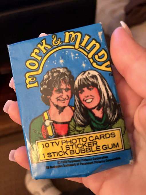 A hand holds a blue packet labeled “York & Wendy,” featuring illustrated characters and text reading “10 TV PHOTO CARDS,” “1 STICKER,” and “1 STICK BUBBLE GUM.”