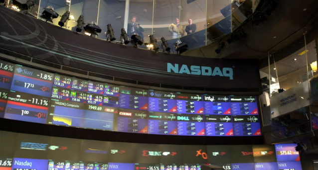 The image shows a curved Nasdaq trading floor display featuring the prominent "NASDAQ" logo and multiple stock tickers with red and green price changes, including visible symbols like SJM, NFLX, and the "NASDAQ Composite" index at 19,469.68. The post highlights Nasdaq's projected May 23 launch of tokenized equity trading and its June pilot of tokenized collateral on the Canton Network via Calypso, themes that align with the exchange's technological innovation focus depicted in the trading screens.