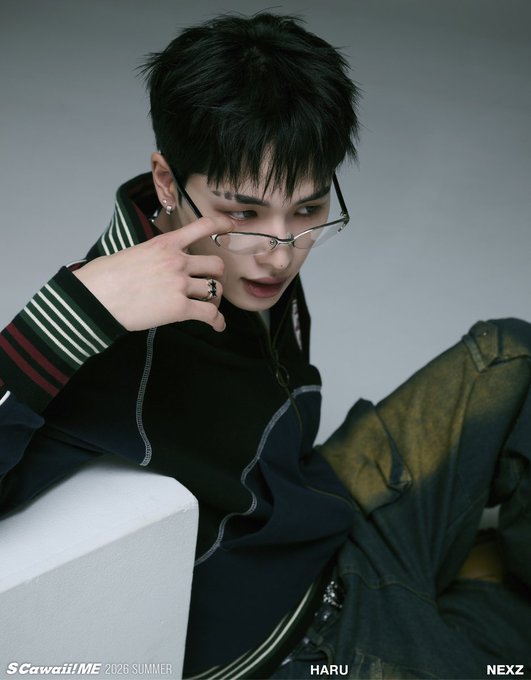 A promotional photo for 'S Cawaii! ME 2026 SUMMER' features K-pop idol HARU from NEXZ, wearing glasses and a black jacket, posing with his hand near his face.
