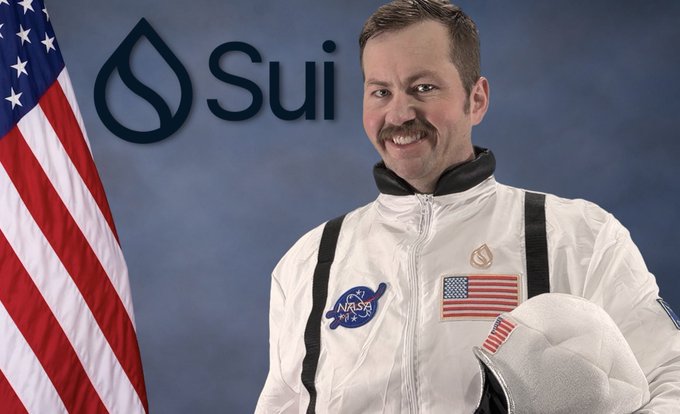 The image features a man dressed as an astronaut standing against a blue background with an American flag behind him. The caption of the image reads "People be like, What do you do for fun? Dude, I'M AN ENTERPRISE COACH. I LIKE TO TALK ABOUT $SUI, WORK ON $SUI, GROW THE $SUI, AND START THE NEXT BUSINESS ON $SUI."