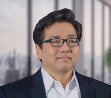 A man wearing a suit jacket and glasses stands alone against a blurred office background of windows offering an urban view into a cityscape. The image also features details about two cryptocurrency investments: Michael Saylor's Bitcoin position is down approximately $12.3 billion, holding 843,701 BTC with an average cost of $75,701 per Bitcoin; whereas Tom Lee's BitMine's Ethereum treasury is down roughly $10.38 billion, currently holding 5.42 million ETH.