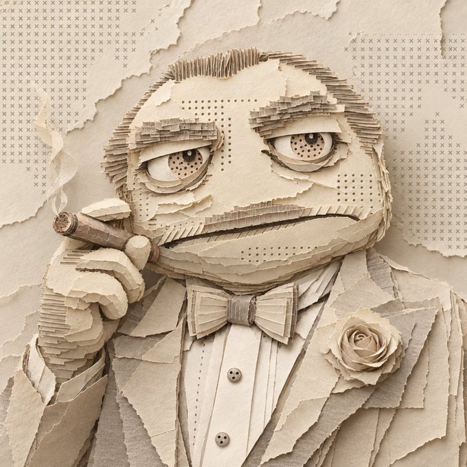 A detailed 3D paper craft sculpture of a tired-looking frog wearing a tuxedo with a bow tie and rose boutonniere, holding a cigar, set against a background of 'x' patterns.