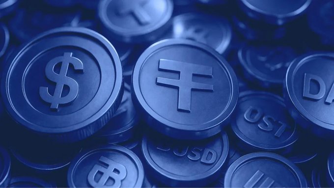 A pile of dark blue coins displays currency symbols like the dollar sign ($) and "USD," visually representing the concept of a digital stablecoin. The image ties directly to the announcement of OUSD, a new USD-backed stablecoin being launched by major financial and crypto companies including Visa, Stripe, Mastercard, BlackRock, and Coinbase.
