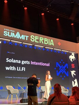 A speaker presents on stage at Solana Summit Serbia, with a large screen displaying "Solana gets Intentional with LI.FI," as the event highlights the introduction of Intents on Solana featuring LI.FI protocol representative Tanja.