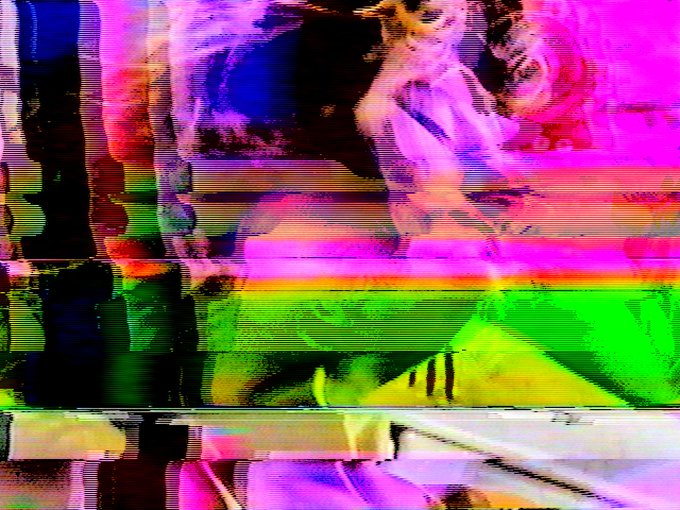 A heavily distorted, glitch-art style image displays fragmented horizontal bands of bright neon pink, green, blue, and yellow.