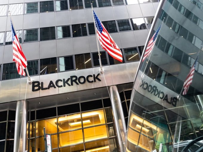 The entrance to BlackRock's office building is shown, featuring the company's name prominently displayed above the doorway alongside American flags, with the building's glass facade reflecting the signage.

The image depicts BlackRock's corporate headquarters, visually supporting the claim that the investment giant is engaging with XRP and the XRP Ledger following its partnership with Ripple through the ISDA trade association.
