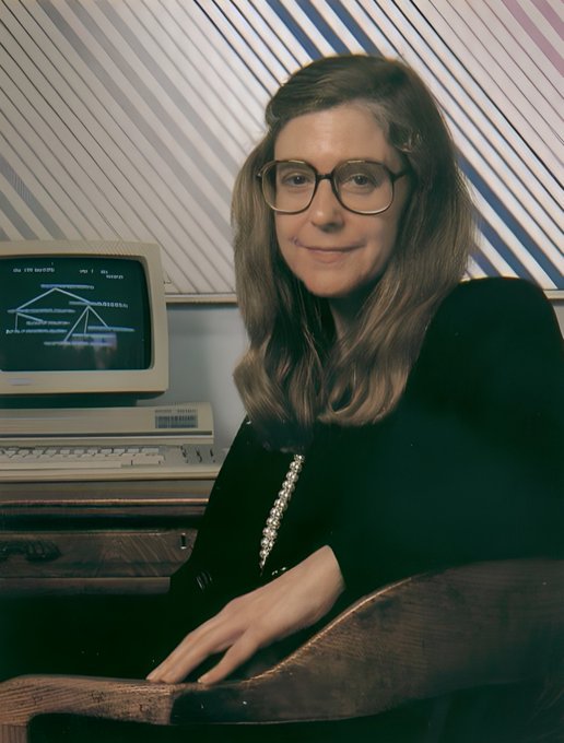 A vintage-style portrait of a woman with glasses and a pearl necklace posing in front of an old computer monitor displaying code.