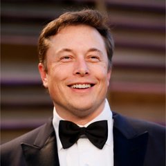 A smiling portrait of Elon Musk wearing a black tuxedo with a bow tie.