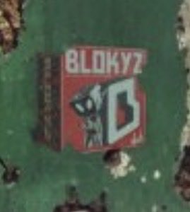 A red square sign on a green background reading 'BLOKYZ' with a stylized character logo.