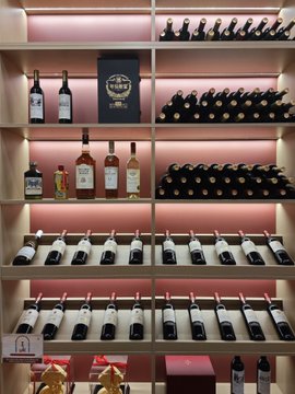 The image displays shelves stocked with various bottles of wine, hinting at the "handsome on-chain assistant" being a valuable or desirable commodity, much like fine wine, as described in the accompanying post. The "hookups" and "snatched up" language suggests a limited or competitive opportunity to acquire this "assistant."