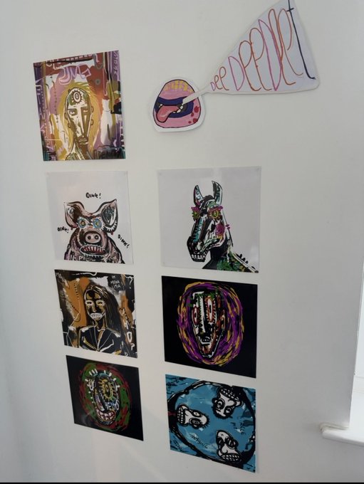 A white surface displaying an art collection including expressive face portraits, an alien/creature drawing, and a hand-drawn 'FREE PEEPEE' sign with a pink megaphone.