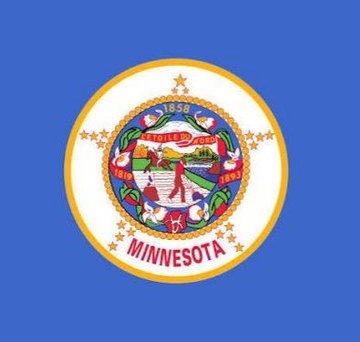 The image shows the flag of Minnesota, featuring the state's seal with "1858," "L'ÉTOILE DU NORD," and "MINNESOTA" prominently displayed on a blue background. The flag visually represents the state where crypto kiosks have just been banned due to nearly $1 million in scam losses affecting residents.