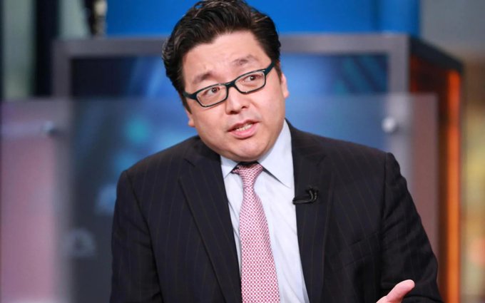 Tom Lee, wearing glasses and a dark pinstripe suit with a pink tie, speaks during what appears to be a television interview. The image relates to the post as he is the Fundstrat CIO behind BitMine's $43 million Ethereum purchase, with the broadcast setting suggesting a recent media appearance where he likely discussed his firm's bullish long-term crypto strategy.
