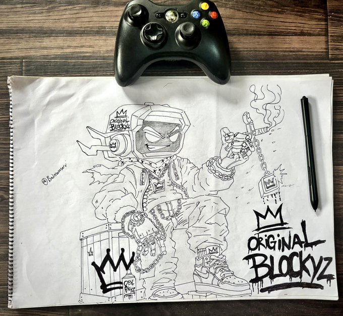 A black and white sketch on paper depicting an 'ORIGINAL BLOCKYZ' character wearing a helmet with horns, chains, and sneakers, shown with a black Xbox controller above and a black pen to the side on a wooden surface.