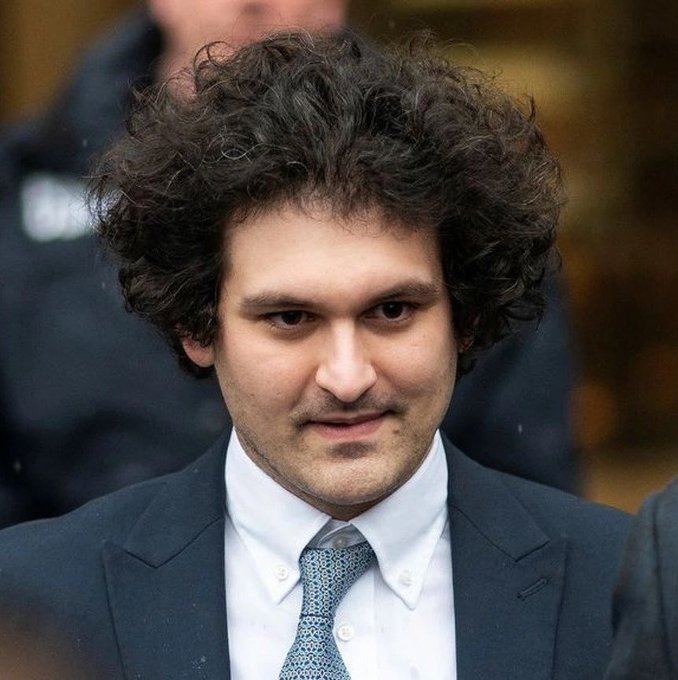 A man with curly hair and a slight smirk, wearing a dark suit, white shirt, and blue patterned tie, stands outdoors.

The image shows Sam Bankman-Fried (SBF), the former FTX founder referenced in the post, which details the staggering $206 billion unrealized value of his once-held equity stakes in companies like Anthropic, SpaceX, Solana, and Robinhood that went unsold before FTX's collapse.