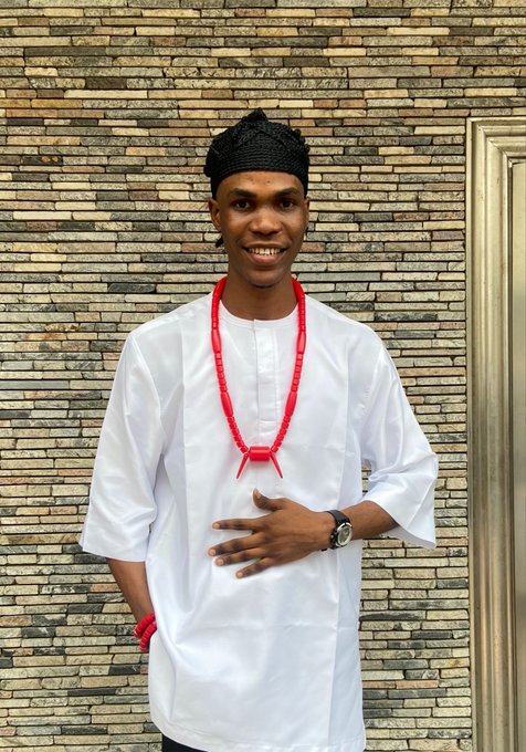 A young man smiles while wearing traditional Nigerian attire—a black patterned cap and red coral beads over a white tunic—at the Solana Summit Nigeria event hosted by Superteam NG. His outfit reflects the Akwa Ibom cultural style referenced in the post, celebrating Nigeria's rich heritage on Day 1 of the summit.