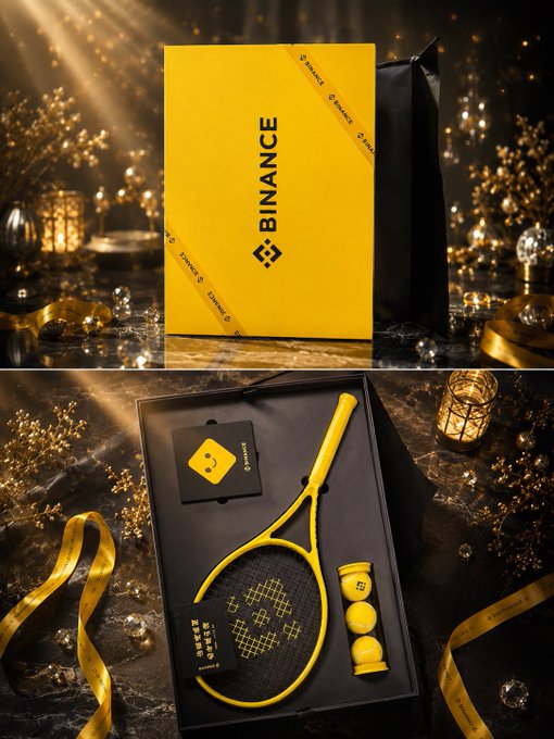 The image features a black box with a yellow ribbon, which appears to be a tennis racket and ball set. The box is placed next to a gold ribbon, creating an elegant presentation. The background of the image includes a dark room with Christmas decorations, adding a festive touch to the scene.